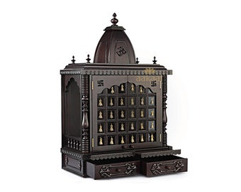 May include: A dark brown wooden temple with a domed roof and intricate carvings. The temple has two doors with glass panels and a small shelf above the doors. The temple has two drawers below the doors. The temple is decorated with gold accents and the word "aakaa" is visible on the front.