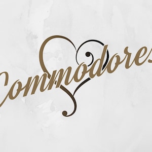 May include: The word "Commodores" in a stylized, cursive font, in a warm brown color, is overlaid on a white background. A heart shape, also in brown and black, is integrated into the design, adding a decorative element. The overall aesthetic is elegant and artistic.