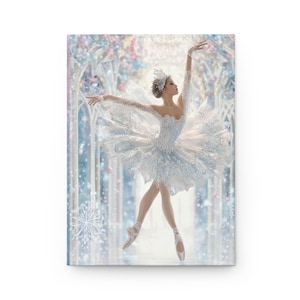 Pode incluir: Um diário com uma bailarina em um tutu branco e azul claro, sapatilhas de ponta e uma coroa de joias. O fundo mostra uma cena de país das maravilhas de inverno com flocos de neve e um efeito suave e desfocado.