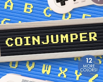 Puede incluir: Un tablero de letras con las palabras "COIN JUMPER" escritas en letras amarillas sobre un fondo negro. El tablero está enmarcado en madera y tiene un fondo azul con letras amarillas dispersas a su alrededor.