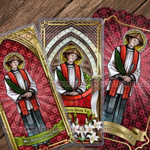 Peut inclure: Trois cartes religieuses colorées avec des bordures dorées représentant un portrait de saint André Dung Lac. Chaque carte a un fond rouge avec un motif floral et un ruban doré sur lequel est imprimé le nom "Saint André Dung Lac".