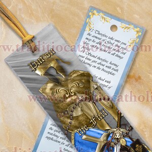 Könnte beinhalten: Ein Lesezeichen mit silbernem Hintergrund und einer goldenen und blauen Illustration der Rüstung Gottes. Der Text "Rüstung Gottes" befindet sich am unteren Rand des Lesezeichens. Der Text "Legt die volle Rüstung Gottes an" befindet sich am oberen Rand des Lesezeichens. Der Text "Nehmt daher an euch die Waffenrüstung Gottes, damit ihr standhalten könnt gegen die Anschläge des Teufels." befindet sich auf der rechten Seite des Lesezeichens.