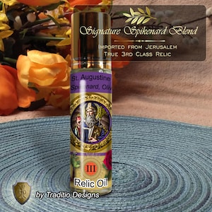 Op de afbeelding: Een heldere glazen fles met een gouden dop, met het label "Signature Spikenard Blend". Het etiket bevat tekst zoals "St. Augustine" en "Relic Oil". De fles heeft een goud en paars ontwerp met een illustratie van een heilige. De tekst "Imported from Jerusalem" is ook zichtbaar.