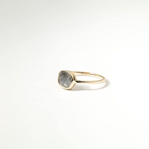 A gold ring with a large, clear gemstone set in the center.