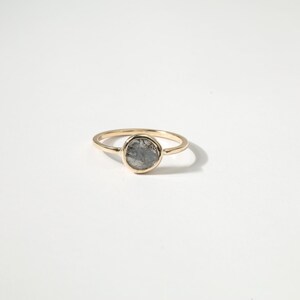 A gold ring with a round stone set in the center.