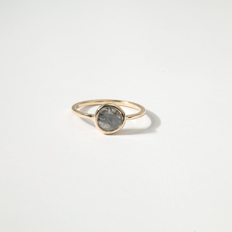 A gold ring with a round stone set in the center.