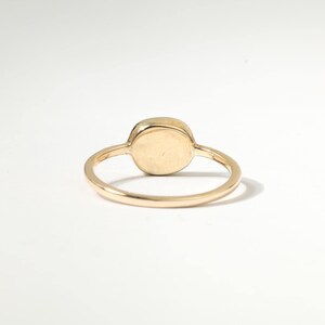 A gold ring with a round stone in the center.