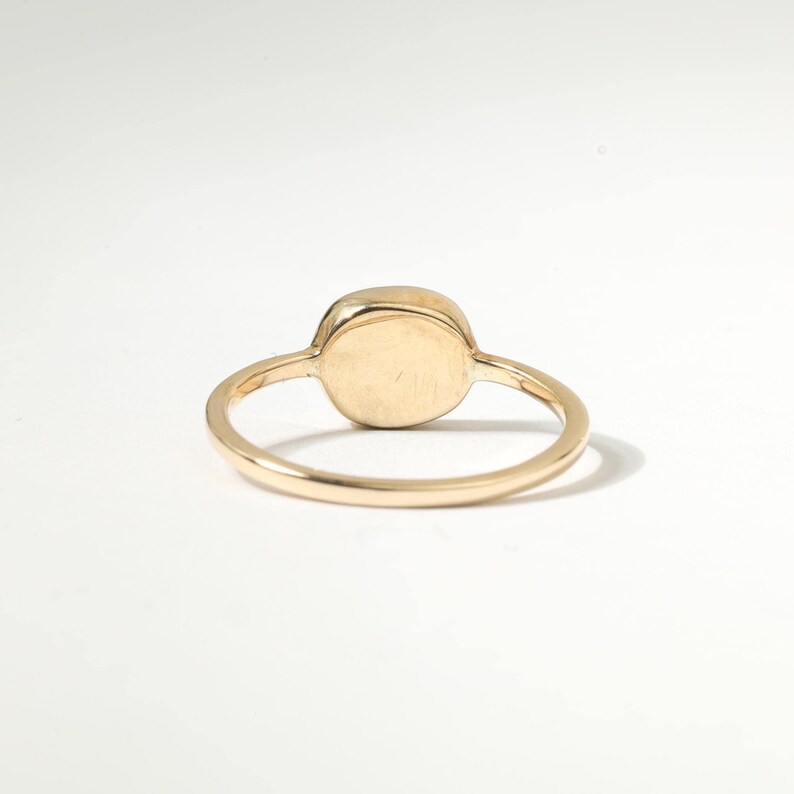 A gold ring with a round stone in the center.