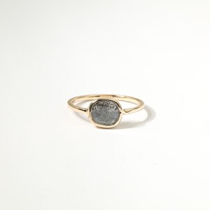 A gold ring with a large, gray stone in the center.