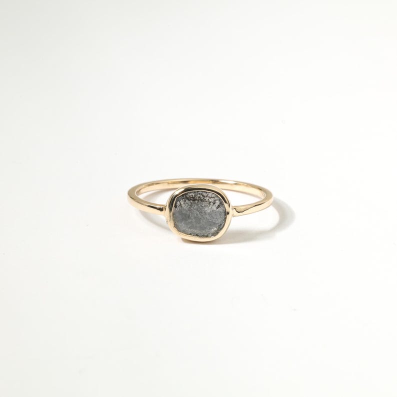 A gold ring with a large, gray stone in the center.