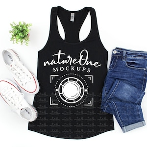 Puede incluir: Camiseta de tirantes negra con un diseño gráfico blanco que dice "nature One MOCKUPS" y un círculo blanco con un marco blanco alrededor. La camiseta está colocada sobre una superficie blanca con un par de zapatillas blancas y unos vaqueros azules.