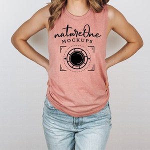 Peut inclure: Un débardeur rose sans manches avec le texte "natureone mockups" et un graphique d'un objectif d'appareil photo à l'intérieur d'un cercle.