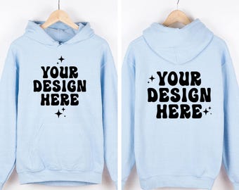 May include: A light blue hooded sweatshirt featuring the black text "YOUR DESIGN HERE" in a bold, wavy font on both the front and back. The design includes small four-pointed star accents above and below the text. The hoodie has long sleeves.