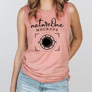 Peut inclure: Un débardeur rose sans manches avec le texte "natureOne MOCKUPS" et un graphique noir et blanc d'un objectif d'appareil photo dans un cadre carré.