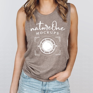 Peut inclure: Un débardeur marron sans manches avec le texte "natureOne MOCKUPS" et un graphique représentant un cercle avec un cercle plus petit à l'intérieur. Le débardeur est porté par une personne.