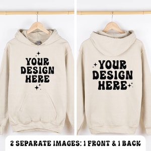 Op de afbeelding: Een beige hoodie met de zwarte tekst YOUR DESIGN HERE in een vet, golvend lettertype op de voor- en achterkant. Het ontwerp bevat kleine vierpuntige steraccenten boven en onder de tekst, met een zichtbare kangoeroezak aan de voorzijde.
