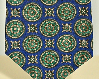 May include: A blue silk tie with a repeating pattern of green and gold circles and squares.