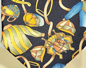 May include: A navy blue silk tie with a repeating pattern of horseshoes, jockey helmets, and jockey silks in yellow, orange, and blue.