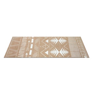 May include: A tan yoga mat with a white geometric pattern. The pattern includes triangles, arrows, and lines.