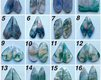 May include: A collection of sixteen pairs of polished, multi-colored agate gemstones in various shapes, including teardrop, oval, rectangular, and triangular cuts, featuring natural moss-like inclusions and swirling patterns in green, blue, and white.