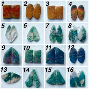 May include: A collection of sixteen pairs of polished, multi-colored gemstones in various shapes including rectangles, ovals, teardrops, and triangles. The stones feature diverse patterns and inclusions in shades of green, red, brown, and blue.