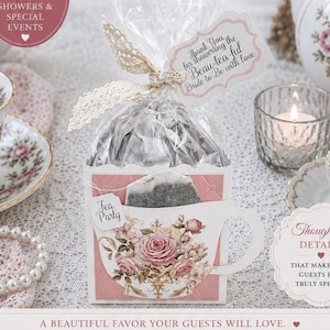 May include: A square favor box featuring a pink and white floral teacup design, containing a tea bag. The box is tied with a cream lace ribbon and a tag that reads, Thank You for showering the Beau-tea-ful Bride-to-Be with love, and a small tag labeled Tea Party.