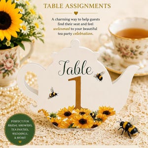 May include: White teapot-shaped table number with a gold number 1. The base is decorated with sunflowers and bees. The text reads "Table Assignments" and "Perfect for bridal showers, tea parties, weddings, & more!"