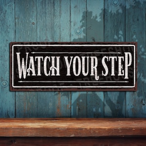 Watch Your Step • Black & White Rustic Looking Aluminum Sign • Color Imprint on Rustproof Aluminum • Customizable  • Made in USA • THC2655-A