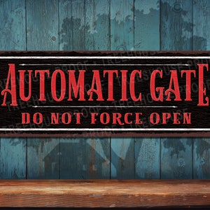 May include: A black and red metal sign with the text "Automatic Gate Do Not Force Open". The sign has a rustic, weathered look.