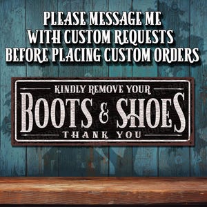 May include: A rustic wooden sign with black paint and white lettering. The sign reads "Kindly remove your boots & shoes. Thank you."