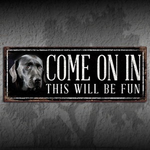 May include: Black and white metal sign with a black Labrador Retriever's head in the upper left corner. The sign reads "Come on in this will be fun".