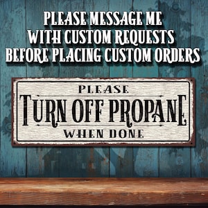 May include: A white metal sign with black text that reads "PLEASE TURN OFF PROPANE WHEN DONE". The sign has a rustic, distressed look and is mounted on a blue wooden wall.