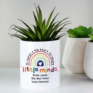 May include: White ceramic planter with a rainbow design and the text "It takes a big heart to shape little minds". The planter also includes the text "Emily Jones, The Best Tutor, Love Gemma".