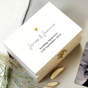 May include: White wooden box with a gold heart and the text "James & Joanna Wedding Memories 25th September 2024" on the lid.