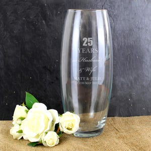 May include: A clear glass vase with the text "25 YEARS as Husband & Wife MATT & JULIE 15TH MAY 2020" etched on the side.