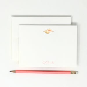 May include: A white card with a seashell illustration and the name "Adelaide" written in pink script.