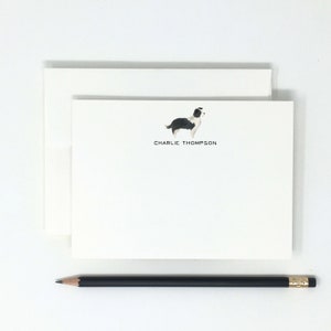 May include: White stationery with a black and white illustration of a dog and the text "CHARLIE THOMPSON" printed in black.