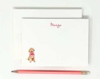 May include: A white card with the name "Margo" written in pink script. A watercolor illustration of a light brown dog wearing a pink bow is in the bottom center of the card.