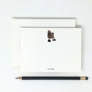 May include: A white card with a brown poodle illustration and the name "Eloise" printed in black at the bottom.
