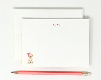 May include: A white card with a small illustration of a golden doodle puppy wearing a pink bow. The text "XOXO" is printed in red at the top of the card.