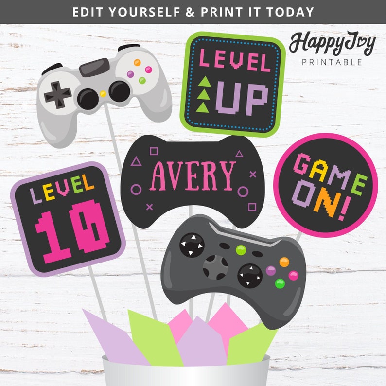 May include: A set of six printable game-themed photo booth props. The props feature a pink and black color scheme with green and yellow accents. The props include a game controller, a level up sign, a level 10 sign, a game on sign, and a sign that says "Avery".
