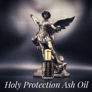 May include: A dark, ornate bottle of Holy Protection Ash Oil with a gold cap, set in front of a statue of St. Michael. The statue is bronze-colored and depicts St. Michael with wings and a sword. The text "Holy Protection Ash Oil" is displayed below.