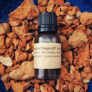 以下が含まれることがあります： 黒いキャップとクリーム色のラベルが付いた小さなガラス瓶が、赤茶色の岩の山の中に置かれています。ラベルには「Scabre Magical Curios」と「Angel Michael Chunk Dust Lightning」と書かれています。ボトルは青い斑点のある表面にあります。