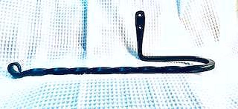 May include: Black metal towel rack with a twisted design. The rack has a hook on one end and a curved arm on the other end.