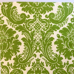 Può includere: Un tessuto bianco con un motivo damascato verde. Il motivo presenta intricati vortici e motivi floreali.