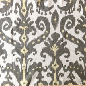 Puede incluir: Primer plano de una tela con un patrón repetitivo de remolinos y diamantes marrones y beige. La tela tiene una superficie texturizada.