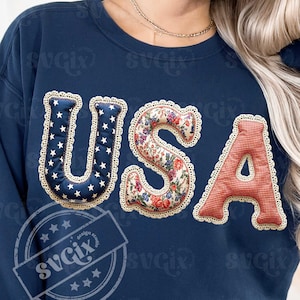 May include: Navy blue sweatshirt featuring the word "USA". The letters are designed with patchwork patterns: the "U" has white stars on navy, the "S" is floral, and the "A" is red gingham. Each letter is trimmed with a scalloped edge.