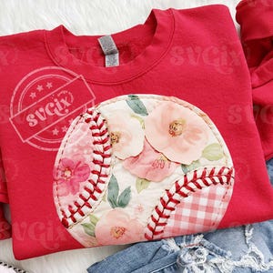 Puede incluir: Una sudadera roja con un diseño de béisbol con detalles florales. El béisbol está hecho de un patchwork de telas florales y de cuadros, con costuras rojas. El diseño está en una sudadera roja.