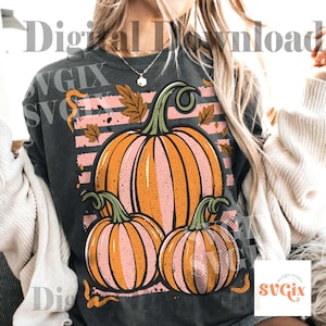 May include: Dark gray sweatshirt featuring a fall-themed graphic. The design includes three pumpkins in shades of orange and pink, with green stems and leaves. The text "Digital Download" and "SVGix" are visible.