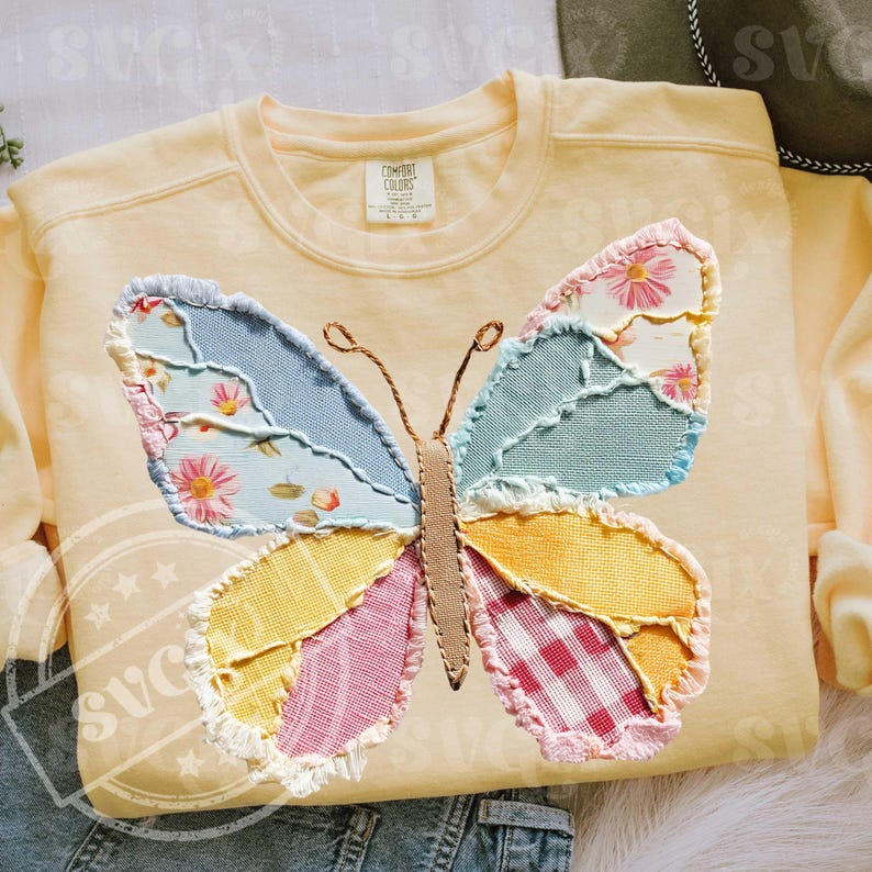 May include: A light yellow sweatshirt featuring a large, colorful butterfly applique. The butterfly wings are made of patchwork fabric in shades of blue, pink, yellow, and green, with floral and gingham patterns. The sweatshirt has a crew neck and the brand name "Comfort Colors" is visible.